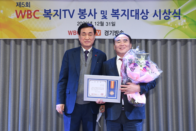 김종길 의원이 봉사 및 복지 대상을 전달받은 뒤, 시상자(김철의 복지TV 경기방송 대표)와 기념촬영을 하고 있다.